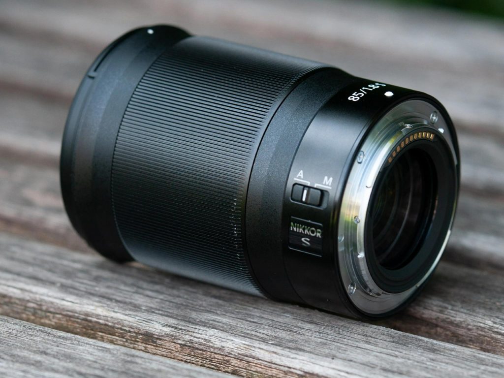 Металевий байонетний вузол Nikon NIKKOR Z 85mm f/1.8 S з гумовим ущільнювачем захисту та перемикачем A/M на дерев'яному столі